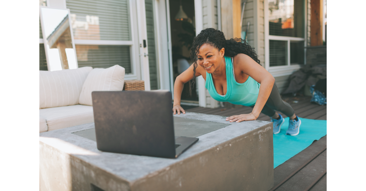 woman doing a push-up while she gets instruction on her computer screen